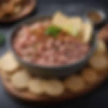 An elegant bowl of tuna spread garnished with spices and served with artisan crackers