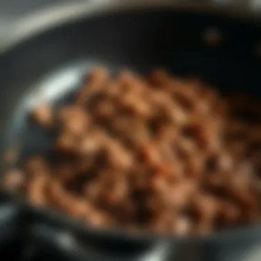 A close-up of a sizzling skillet with ground meat being browned to perfection