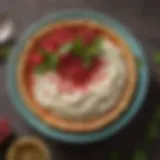 A vibrant bowl of Mutabbal garnished with pomegranate seeds and parsley.